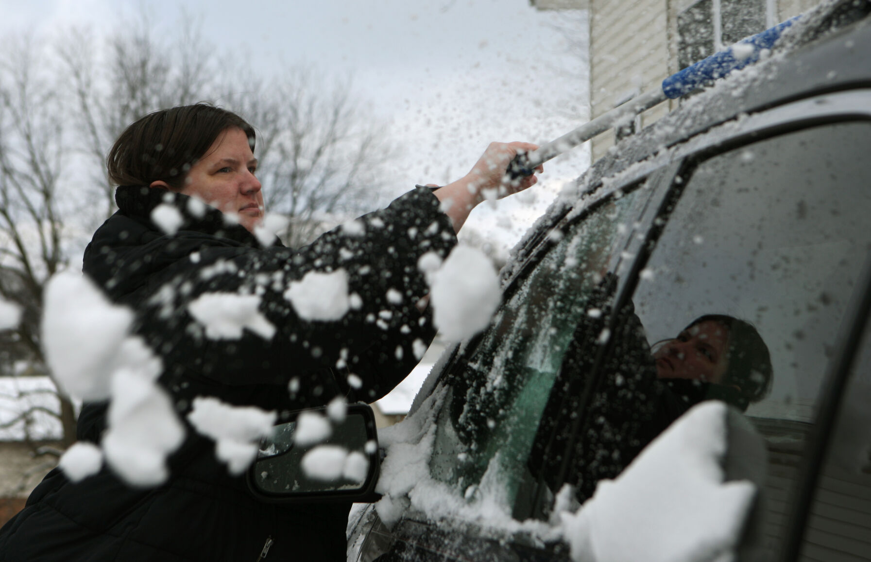 Shawna Monroe brushes snow off her vehicle